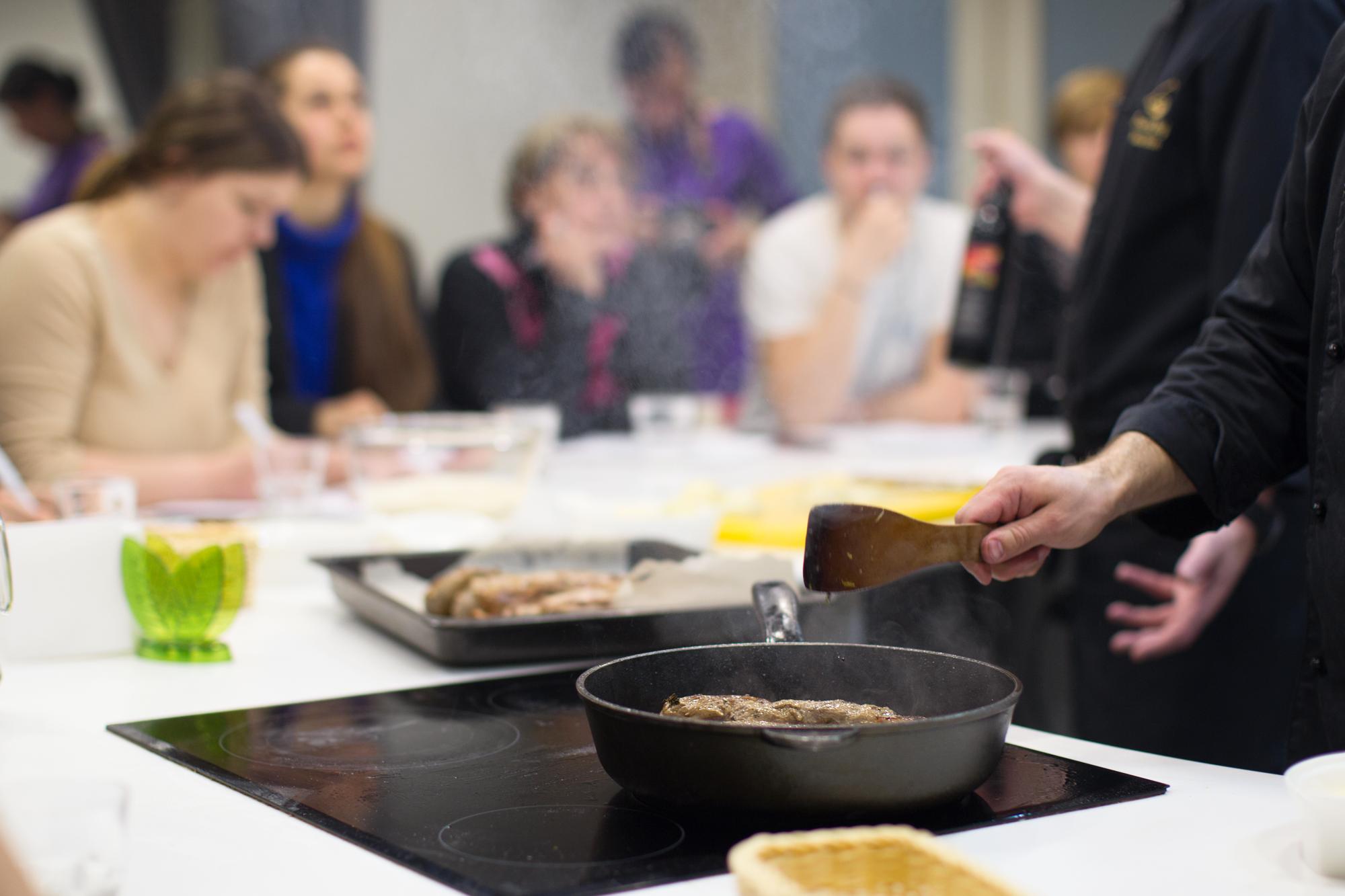 Participant seasoning a pan